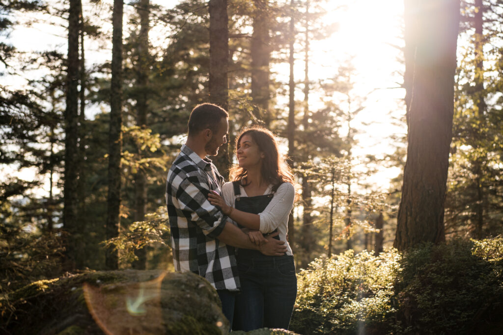 Photographie de couple en forêt avec le couché du soleil, ils se regardent