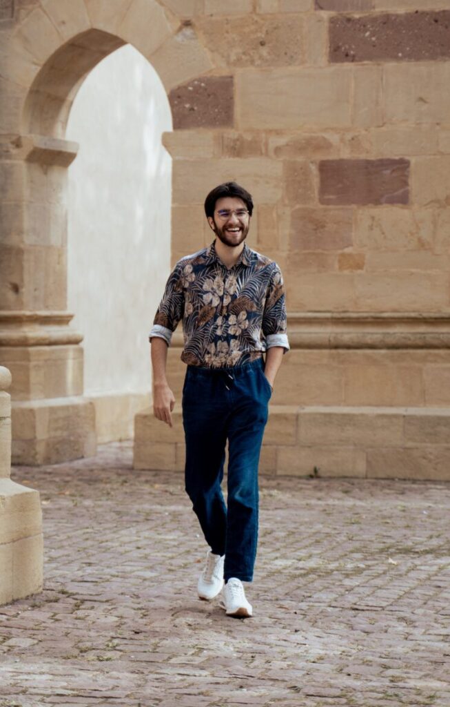 Photographe à Mulhouse marchant dans une rue pavée, ambiance naturelle et authentique